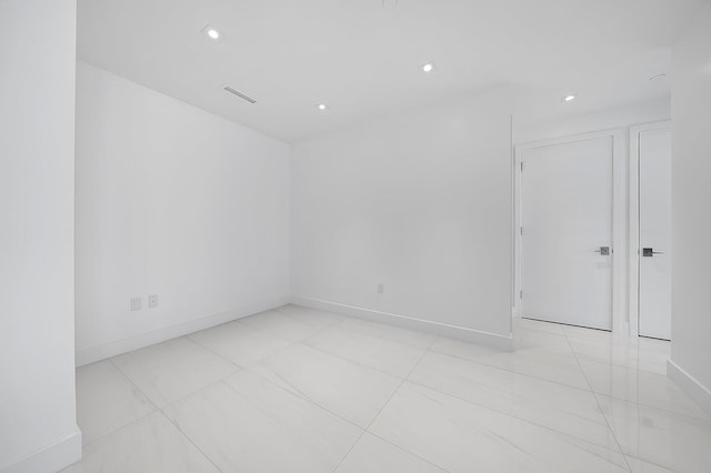 empty room with visible vents, baseboards, and recessed lighting