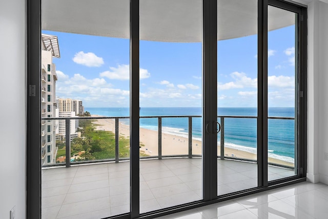 balcony featuring a view of the beach and a water view