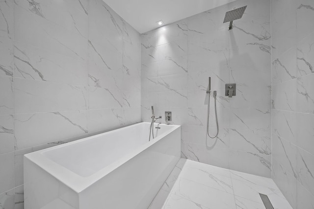 full bath with a soaking tub, a marble finish shower, marble finish floor, and tile walls