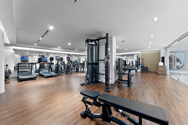 gym featuring recessed lighting, track lighting, and wood finished floors