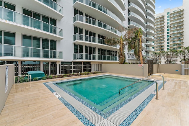 view of pool featuring a grill and fence