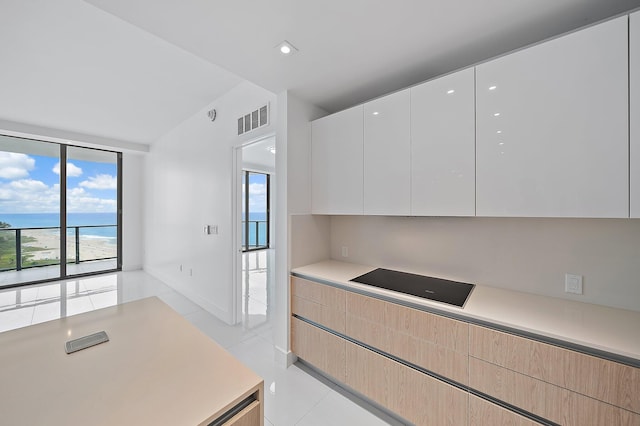 kitchen with light tile patterned floors, light countertops, visible vents, light brown cabinetry, and modern cabinets