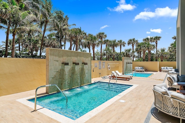 pool with an outdoor hangout area and a patio