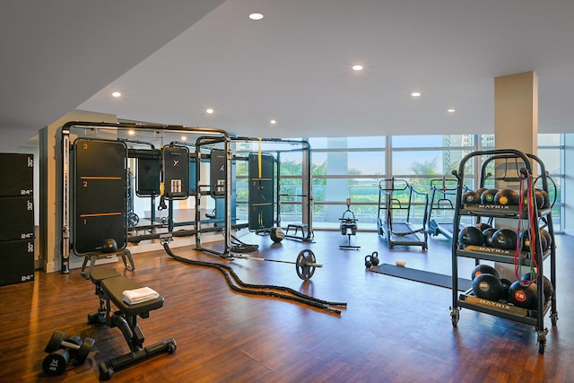 exercise room with expansive windows, wood finished floors, and recessed lighting