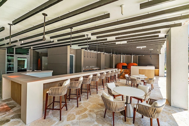 interior space featuring a community bar and stone finish flooring