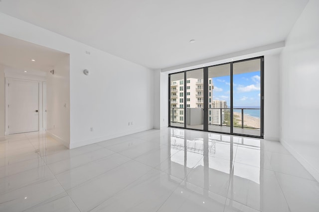 tiled empty room featuring baseboards