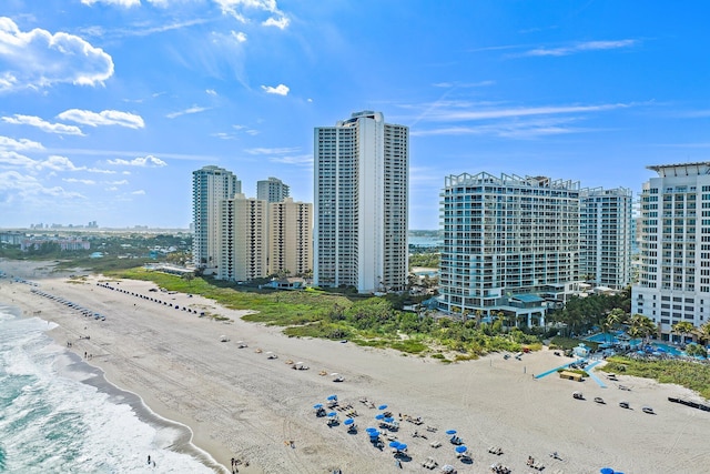 drone / aerial view featuring a city view, a water view, and a beach view