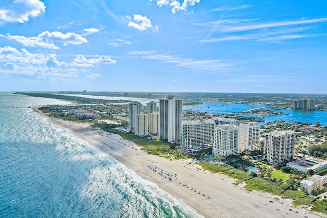 drone / aerial view with a city view, a water view, and a beach view