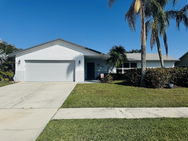 ranch-style house featuring an attached garage, a front lawn, concrete driveway, and brick siding