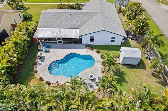 pool featuring a sunroom, a patio area, and a lawn