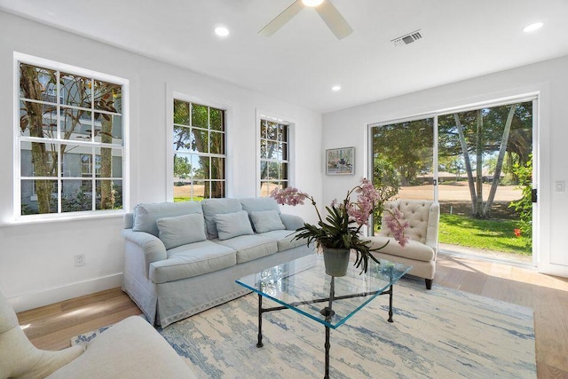 living area featuring baseboards, visible vents, wood finished floors, and recessed lighting