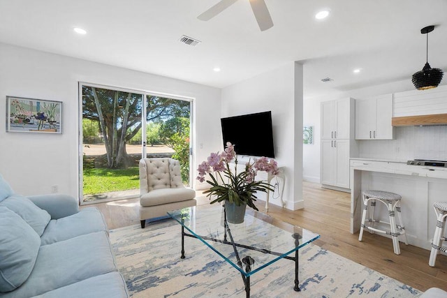 living room with ceiling fan, light wood-type flooring, visible vents, and recessed lighting