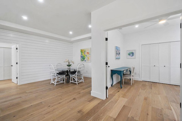 dining room featuring light wood-style floors, recessed lighting, baseboards, and a tray ceiling