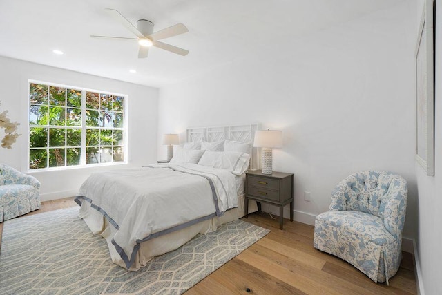 bedroom featuring a ceiling fan, recessed lighting, baseboards, and wood finished floors