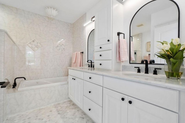 bathroom with double vanity, a bathtub, a sink, and tile walls