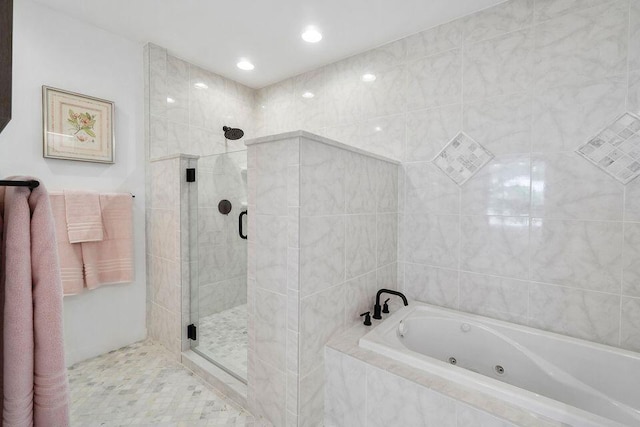 full bath with a stall shower, a jetted tub, tile walls, and recessed lighting