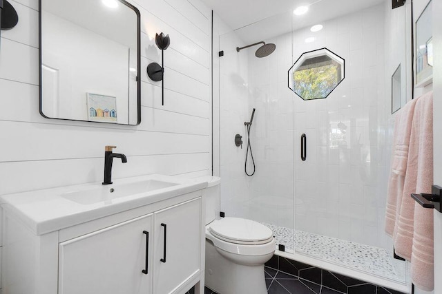 full bathroom with a stall shower, vanity, and toilet