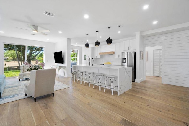 kitchen with light countertops, visible vents, light wood-style floors, a sink, and stainless steel fridge