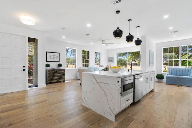 kitchen featuring open floor plan, visible vents, a sink, and stainless steel dishwasher