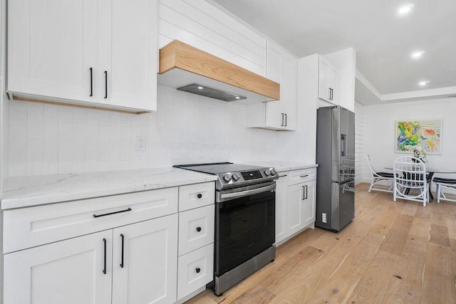 kitchen featuring light stone counters, custom exhaust hood, stainless steel appliances, light wood-type flooring, and white cabinetry