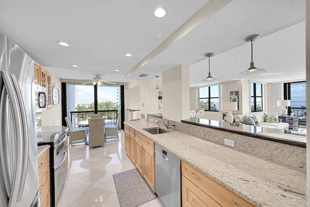 kitchen featuring recessed lighting, appliances with stainless steel finishes, a sink, and light brown cabinetry