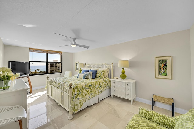 bedroom with ceiling fan, a textured ceiling, and baseboards