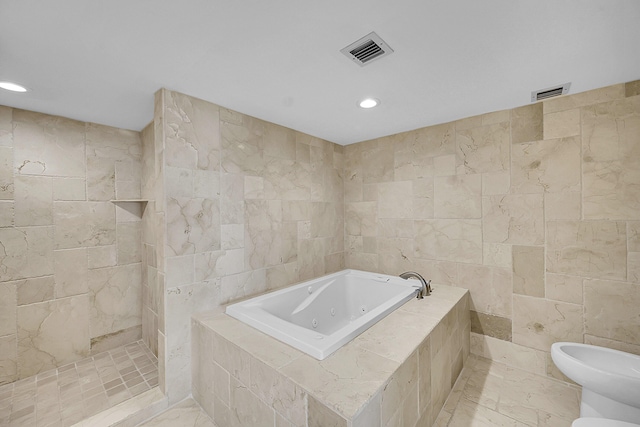 full bathroom featuring visible vents, tile walls, a tub with jets, and a bidet