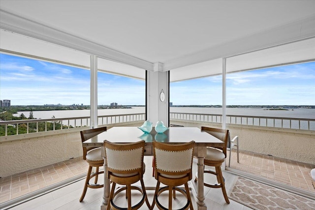 sunroom / solarium featuring a water view