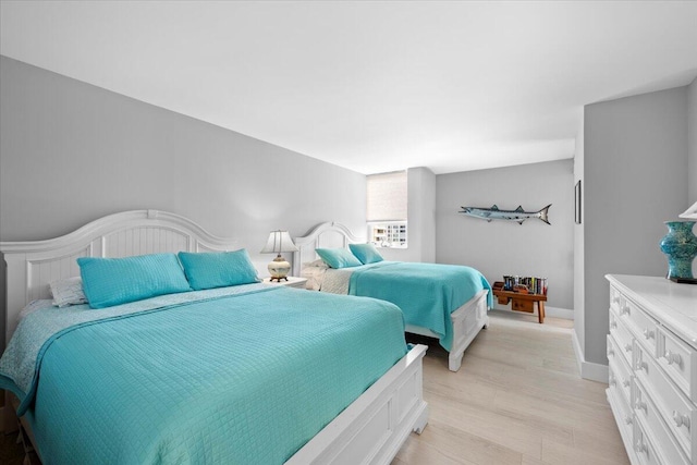 bedroom featuring light wood finished floors and baseboards