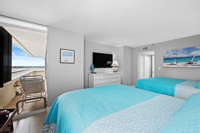 bedroom featuring wood finished floors and visible vents