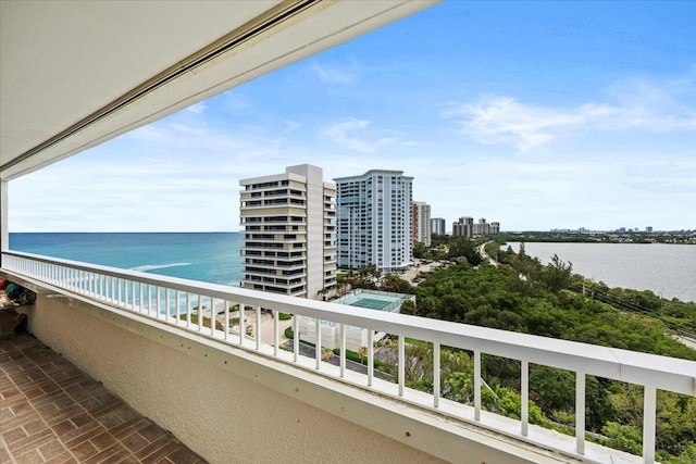 balcony with a water view and a view of city