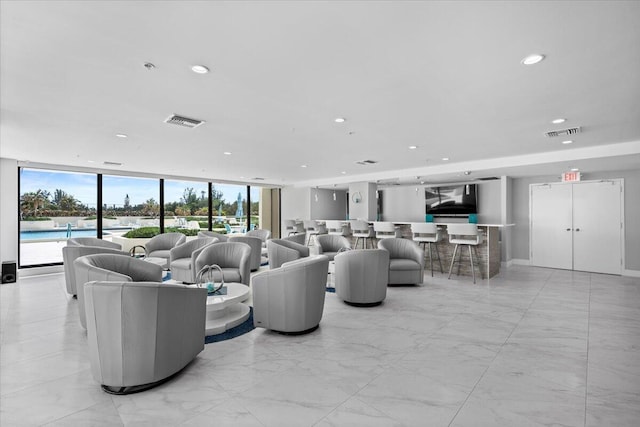 living room with floor to ceiling windows, visible vents, and recessed lighting