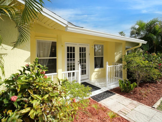 view of exterior entry with french doors and stucco siding