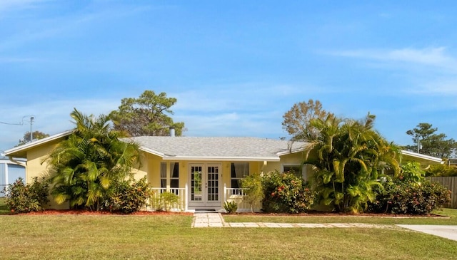 view of front of house featuring french doors, a front yard, and stucco siding