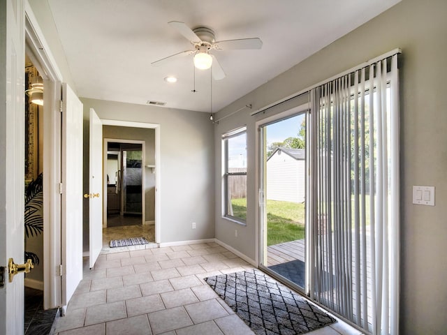 entryway with a ceiling fan, tile patterned flooring, visible vents, and baseboards