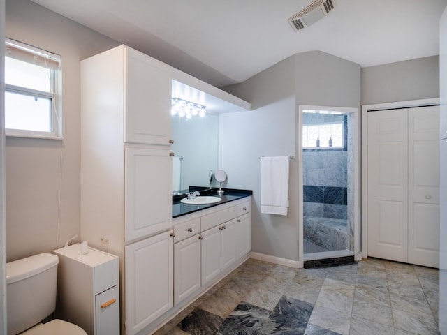 bathroom featuring toilet, plenty of natural light, walk in shower, and visible vents