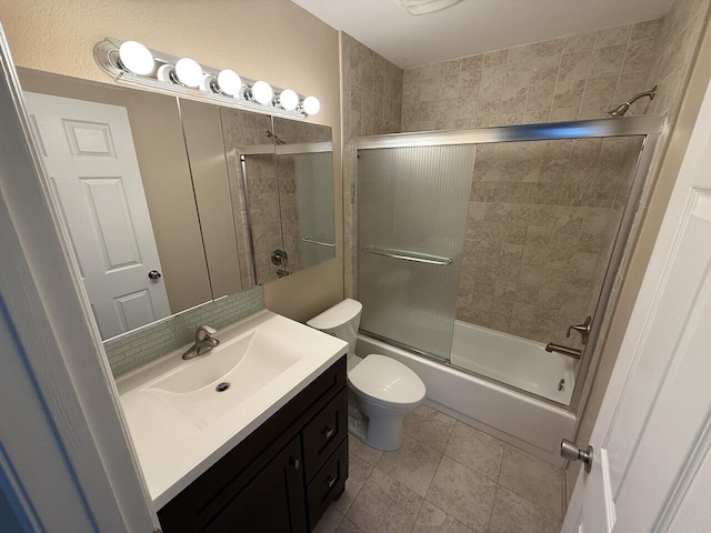 full bath featuring toilet, combined bath / shower with glass door, tile patterned flooring, and vanity