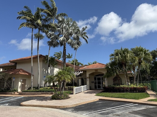 view of building exterior featuring uncovered parking and fence