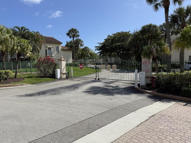 view of street featuring curbs, a gated entry, and a gate