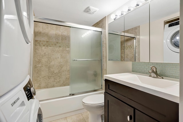 19203 Glenmoor Dr, West Palm Beach, FL 33409 - bathroom featuring washer / clothes dryer, vanity, bath / shower combo with glass door, tasteful backsplash, and tile patterned floors