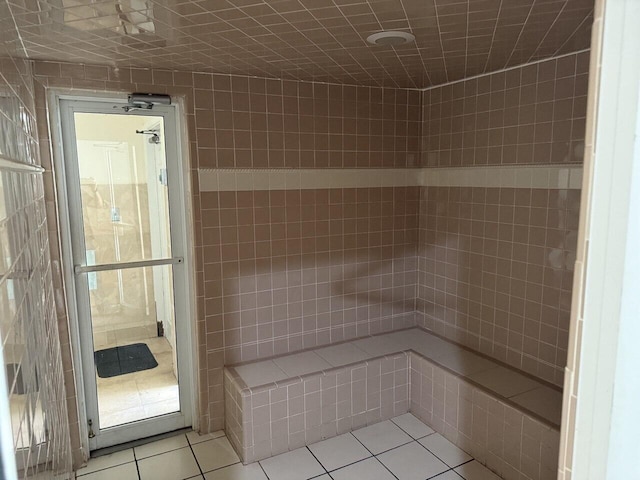 bathroom with a tile shower and tile patterned floors