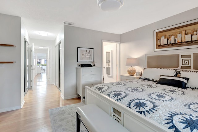 bedroom with light wood-style floors, baseboards, and visible vents