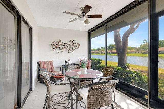 sunroom / solarium featuring a water view and a ceiling fan