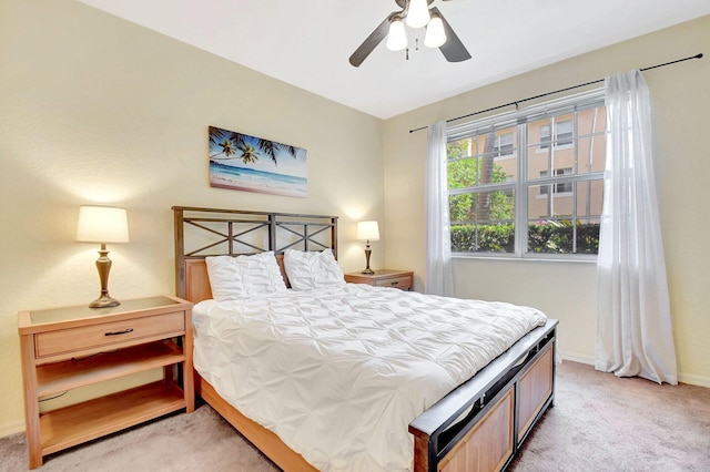 bedroom featuring a ceiling fan, light carpet, and baseboards