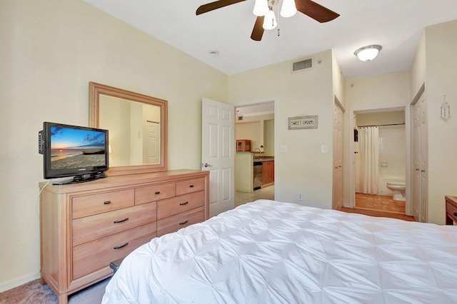 bedroom with ensuite bathroom, baseboards, visible vents, and a ceiling fan