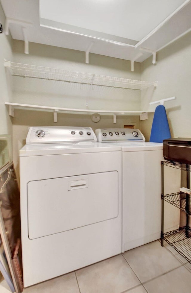 washroom with washing machine and dryer, laundry area, and light tile patterned floors