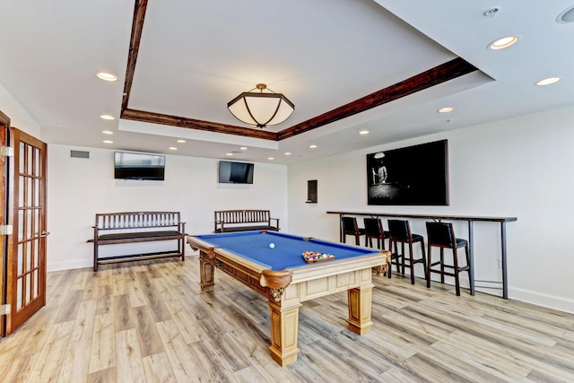 playroom with a tray ceiling, light wood-style flooring, visible vents, and recessed lighting