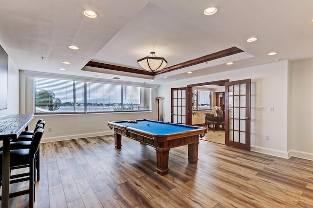 playroom with light wood-style floors, recessed lighting, a raised ceiling, and french doors