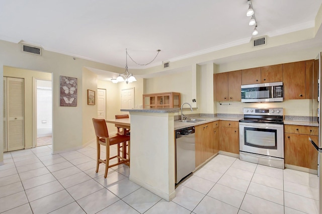 kitchen with a peninsula, visible vents, appliances with stainless steel finishes, and a sink