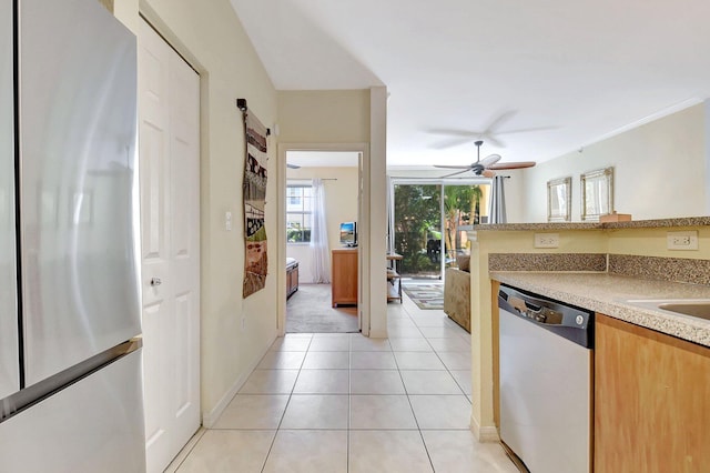 kitchen with light tile patterned floors, dishwasher, ceiling fan, freestanding refrigerator, and light countertops